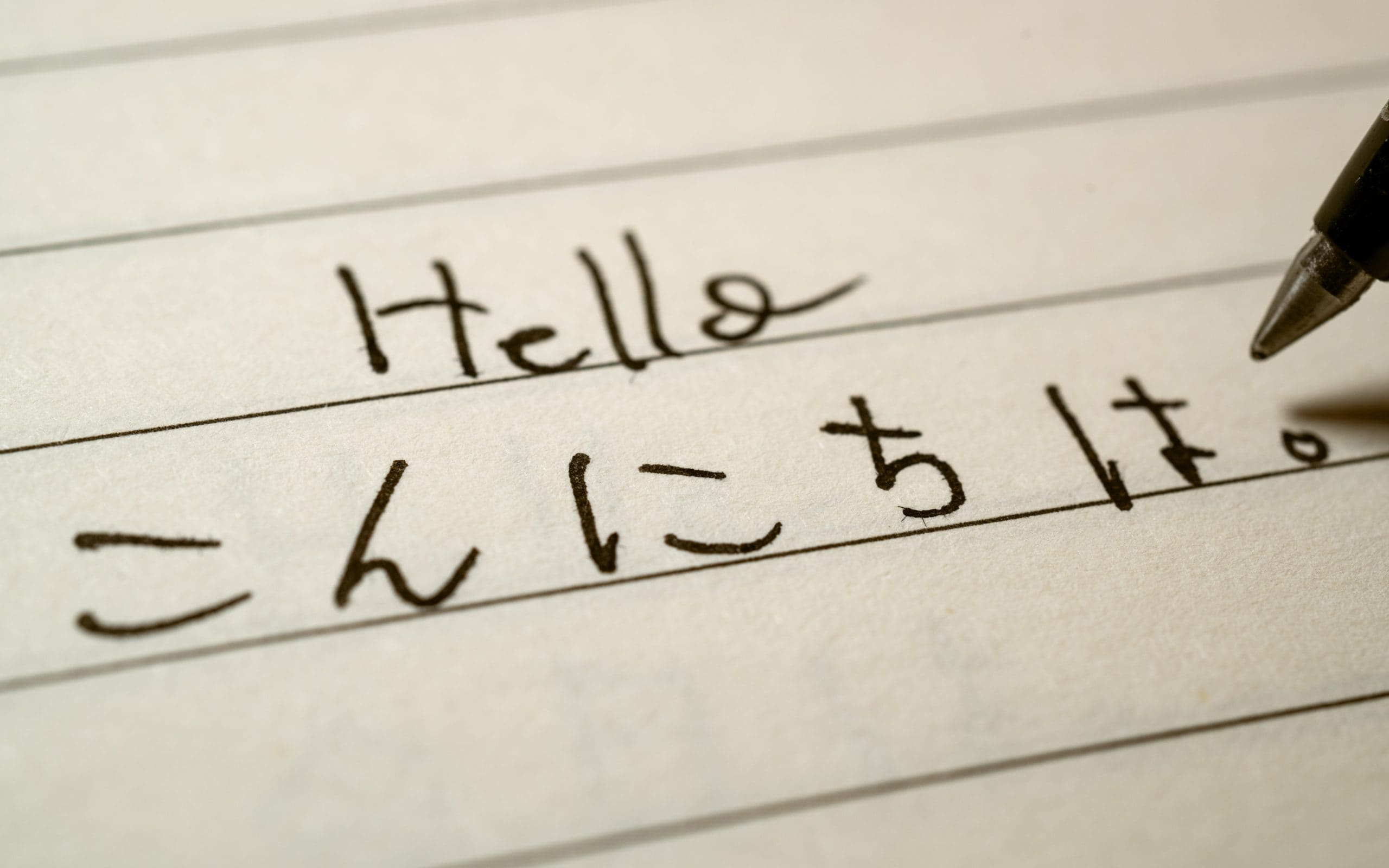 Beginner Japanese language learner writing Hello word in Japanese hiragana characters on a notebook close-up shot Beginner Japanese language learner writing Hello word in Japanese hiragana characters on a notebook close-up shot